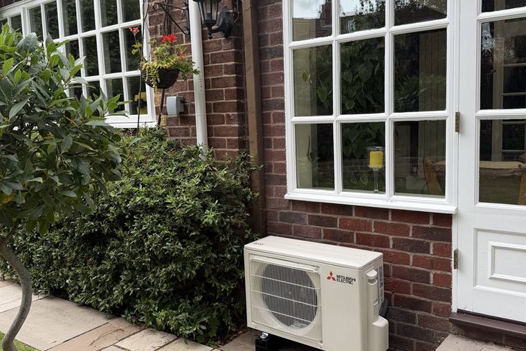 Mitsubishi Electric outdoor unit installed on paving beside a house